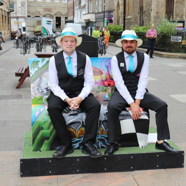 men sat on a book bench