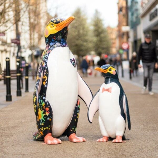 two penguin statues on a high street