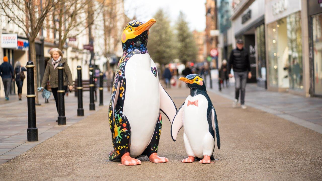 two penguin statues on a high street