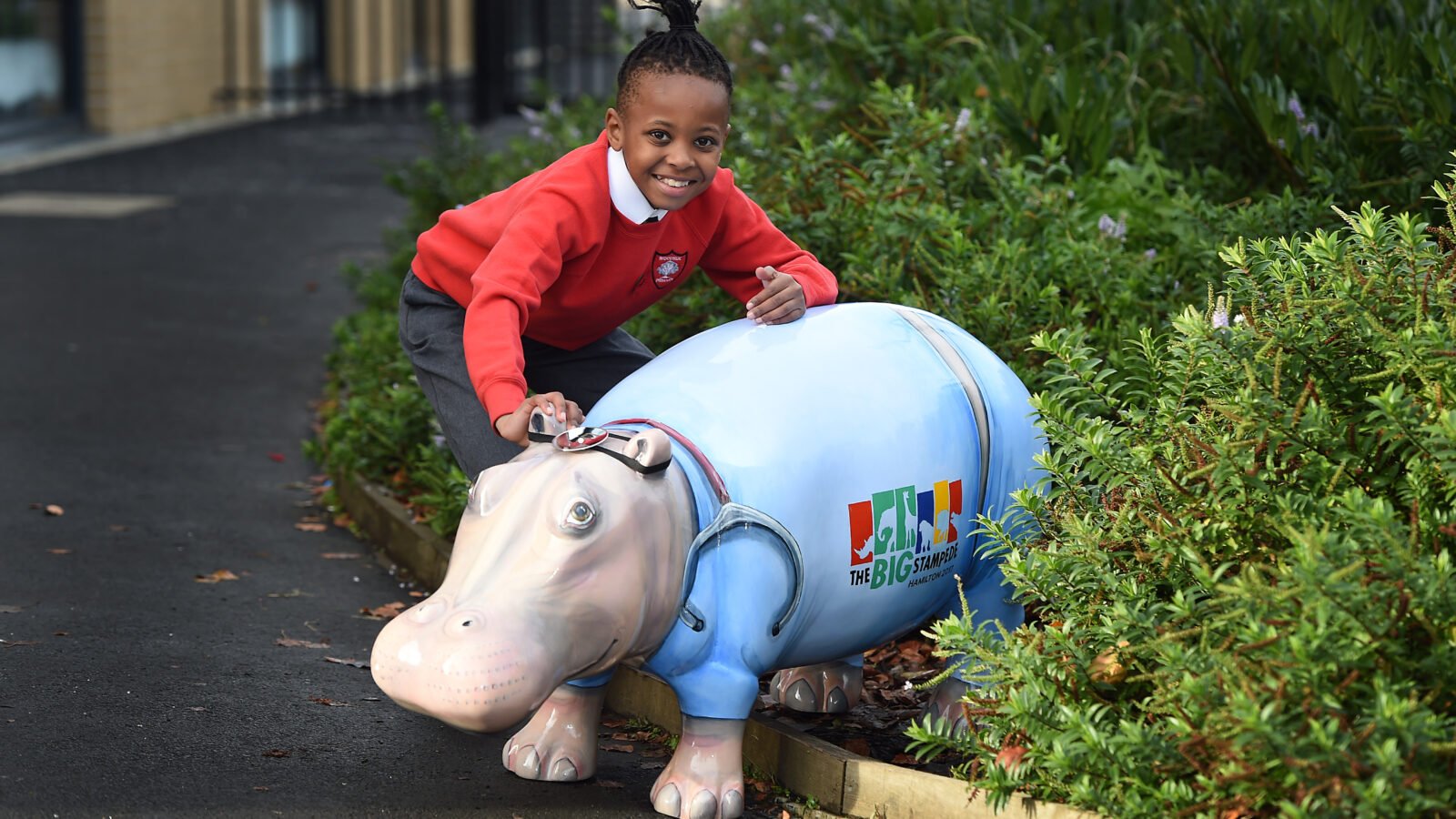 Child posing with Wild in Art Hippo Sculpture